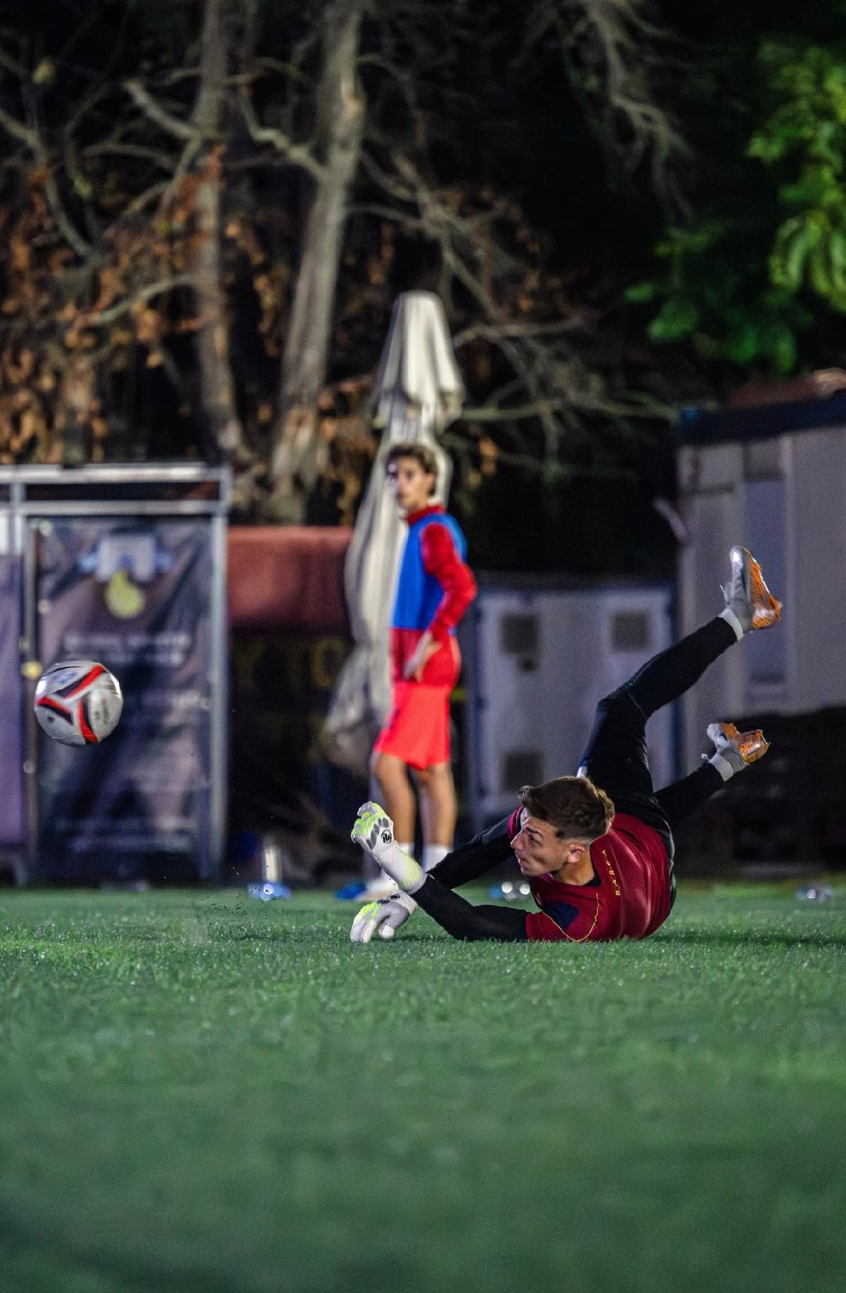 Lucian on the ground after a dive, ball still in the air